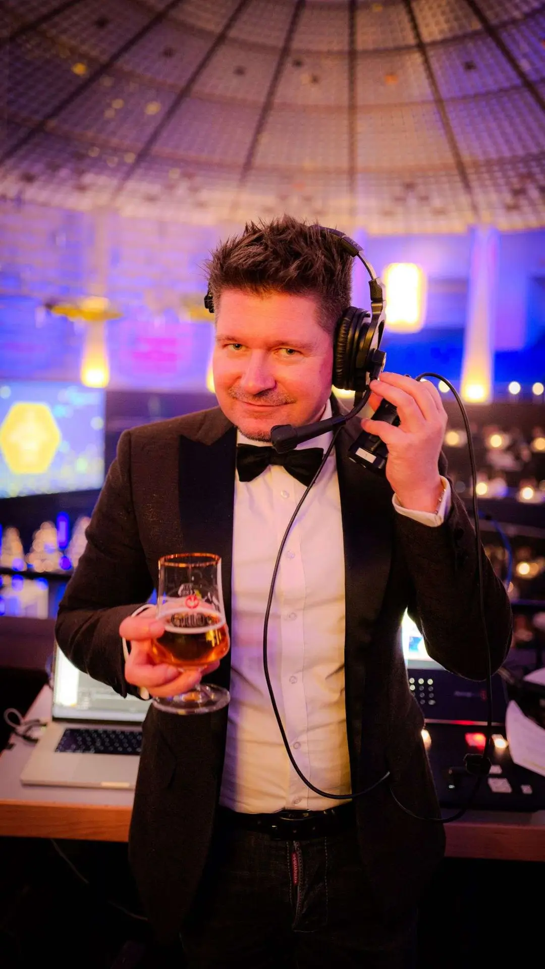 Matthias hält ein Getränkt und trägt ein Headset