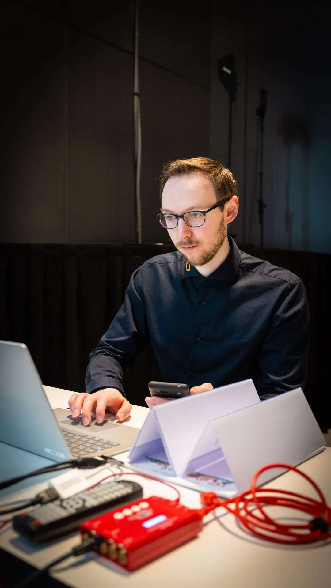 David sitzt in einer Regie vor einem Laptop